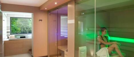 Un moderno spa con cabina de vidrio, un banco y vistas al exterior.