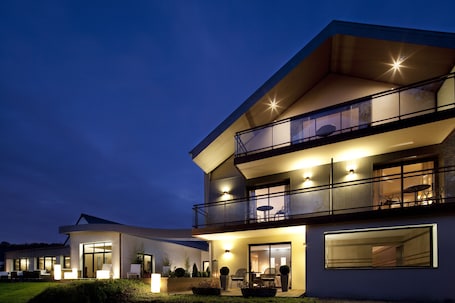 Vista frontal de la propiedad por la tarde o noche