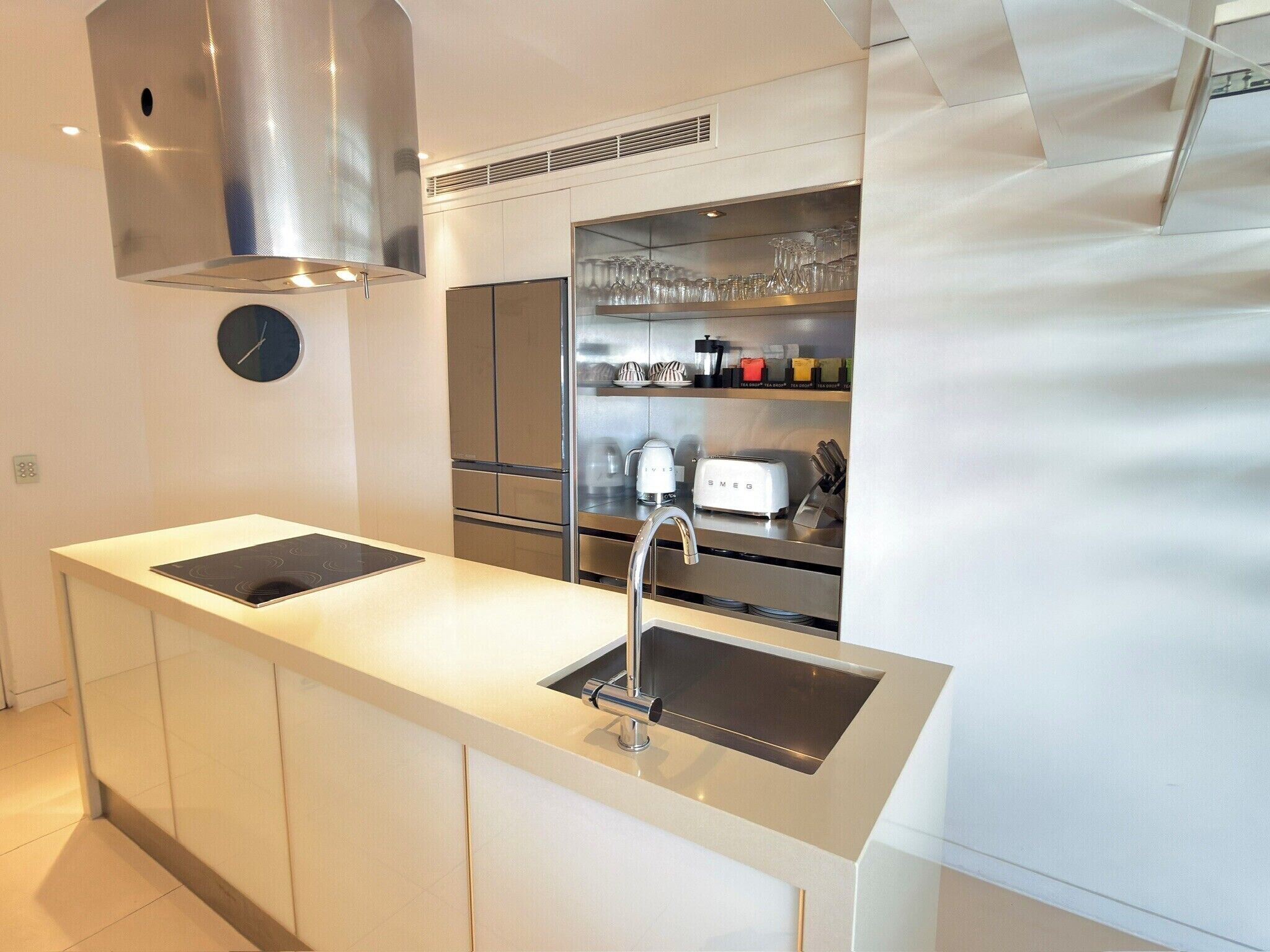 A modern kitchen with a stainless steel range hood, a built-in sink, and a countertop with a toaster.