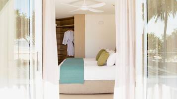 Un dormitorio con cama, ventilador de techo y vista a un armario con ropa.