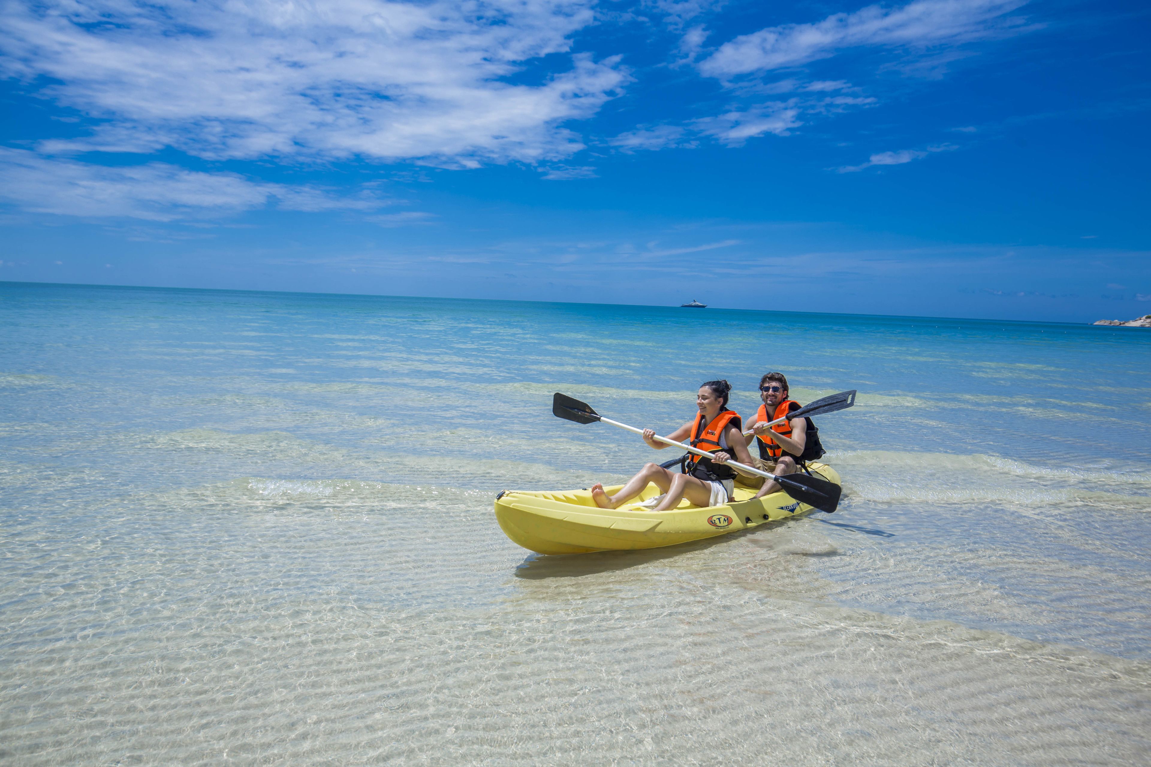 Due persone che fanno kayak in un mare limpido e poco profondo.