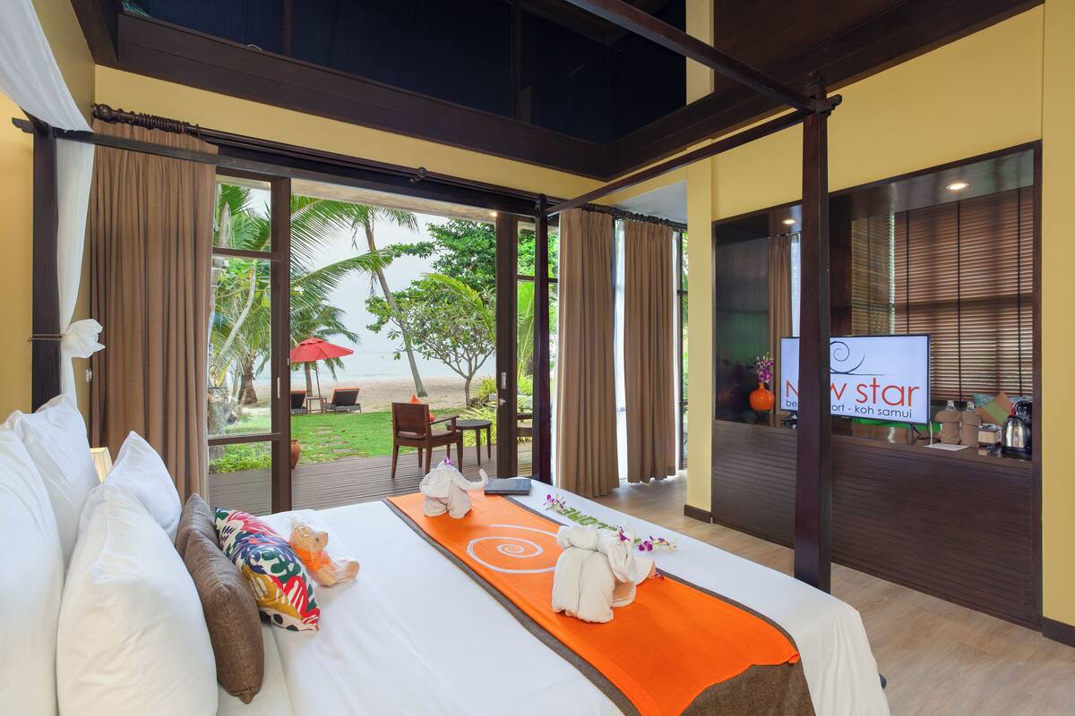 A hotel room with a bed, a view of the outdoors, and a reception desk.
