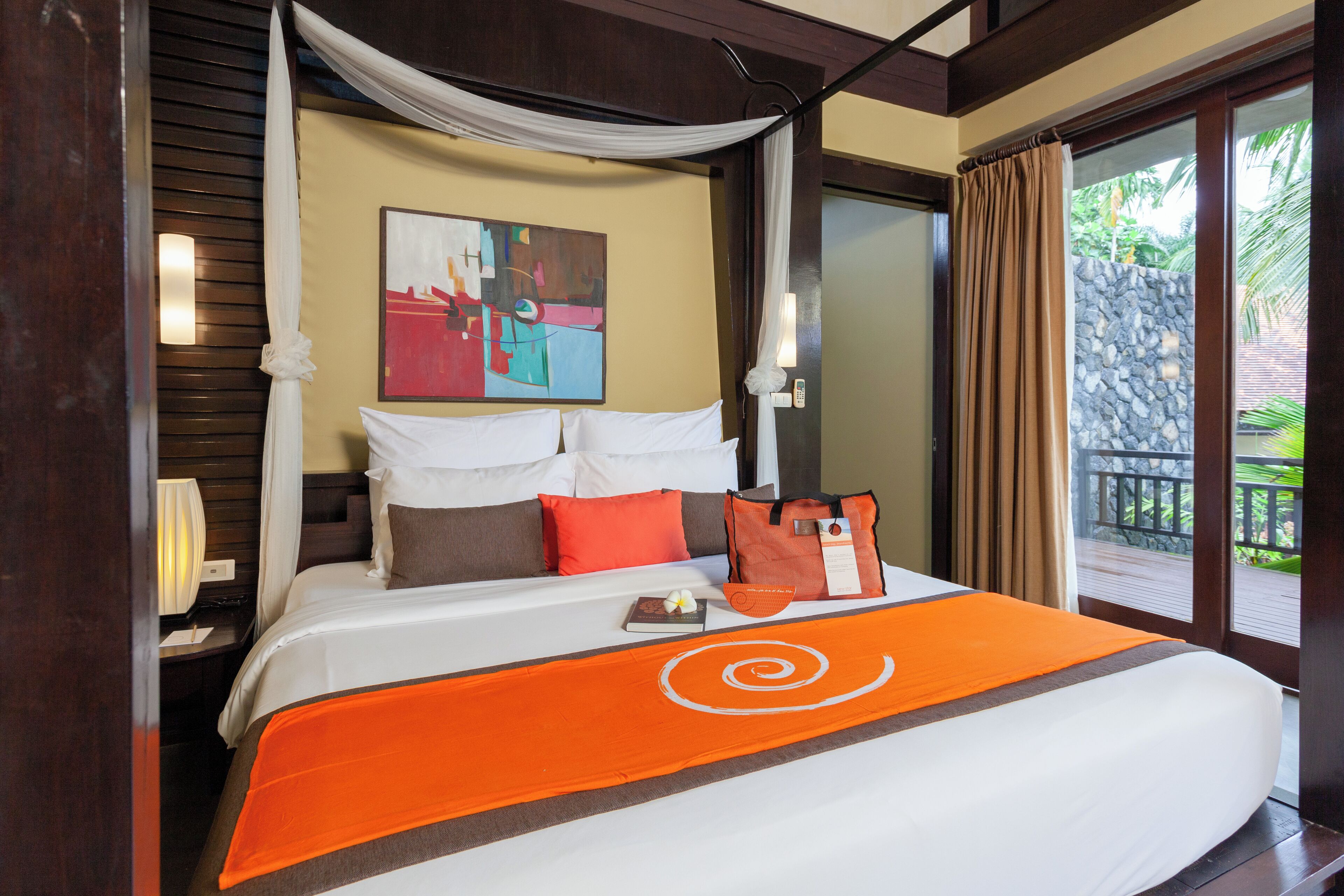 Ein Hotelzimmer mit Bett, einem Bild an der Wand und Blick ins Freie.