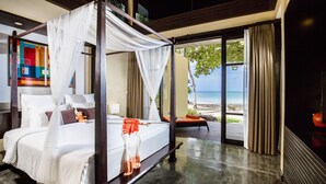 Una cama con dosel con sábanas blancas, vista a la playa y un cuadro grande en la pared.