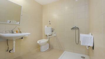 Een moderne badkamer met een wastafel, toilet en douche.