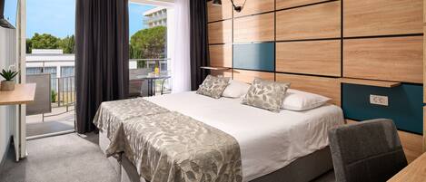 Een moderne hotelkamer met een groot bed, een bureau en uitzicht op de omgeving.