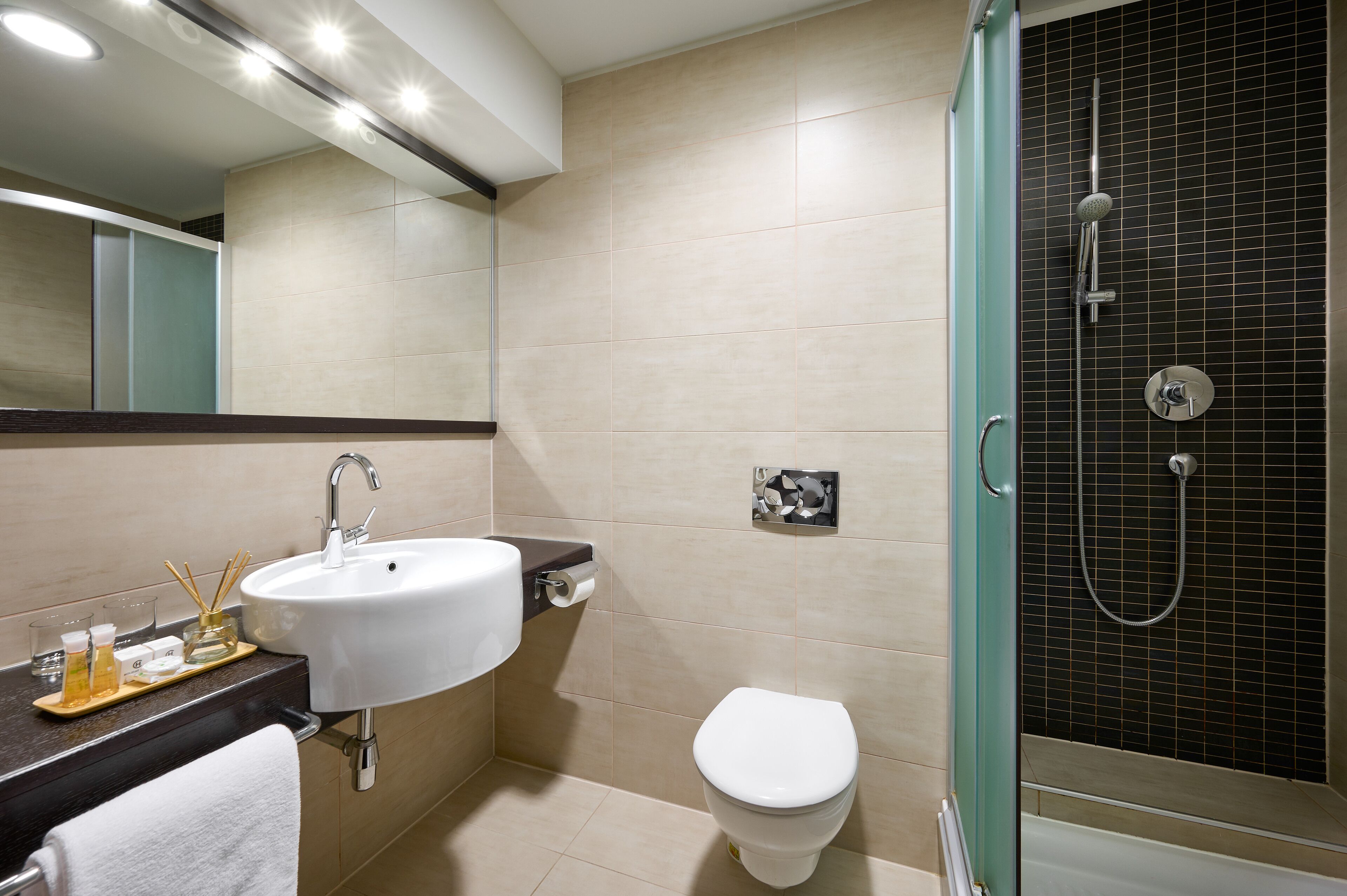 A modern bathroom with a sink, toilet, and shower.