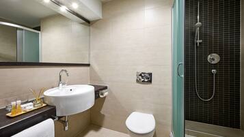 Un baño moderno con lavamanos, inodoro y ducha.
