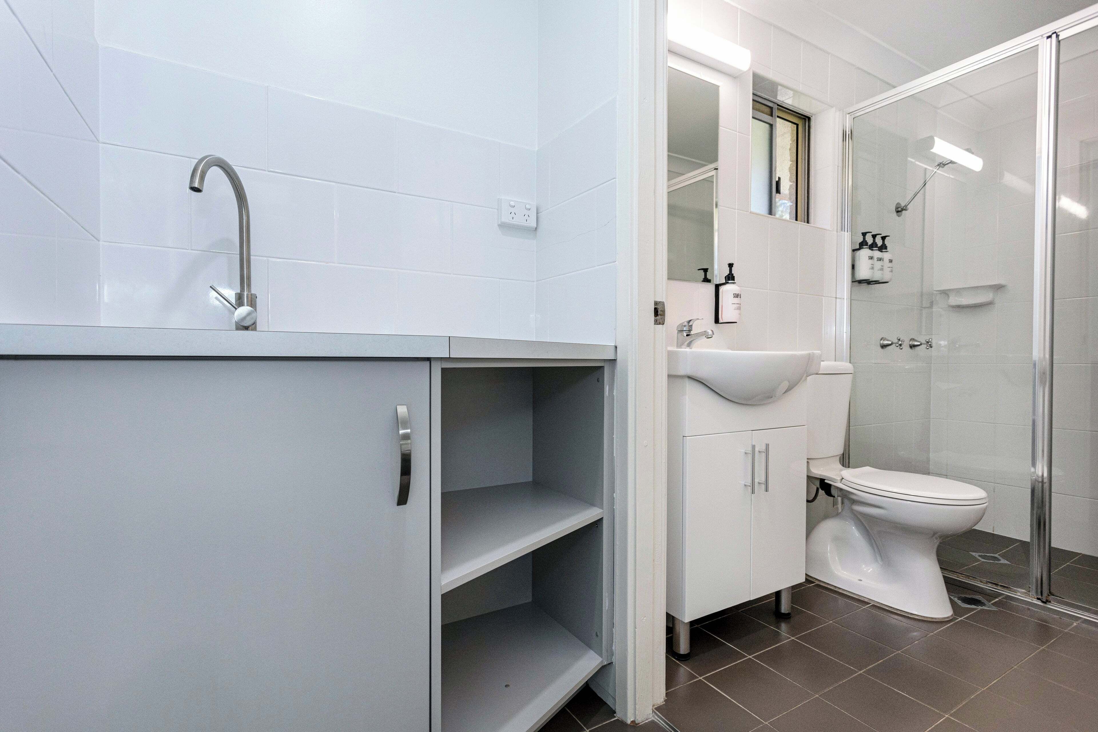 A modern bathroom with a shower, toilet, and sink.