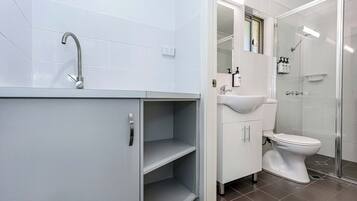 A modern bathroom with a shower, toilet, and sink.