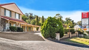 A two-story building with a covered front porch, a sign for Econo Lodge, and a well-maintained lawn. - Econo Lodge Alabaster (Cowra)