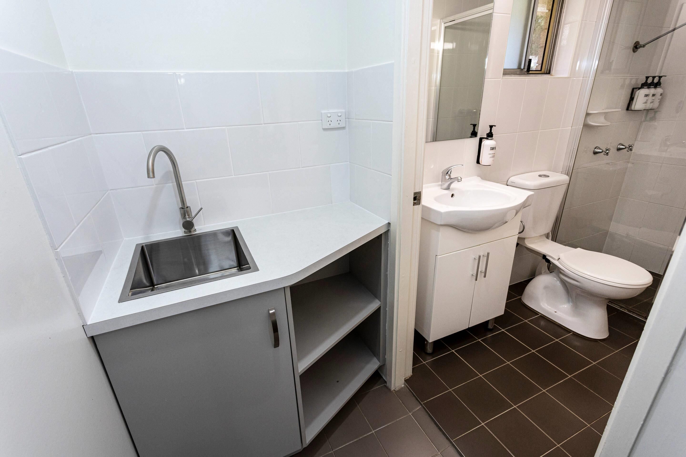A bathroom with a sink, toilet, and shower.