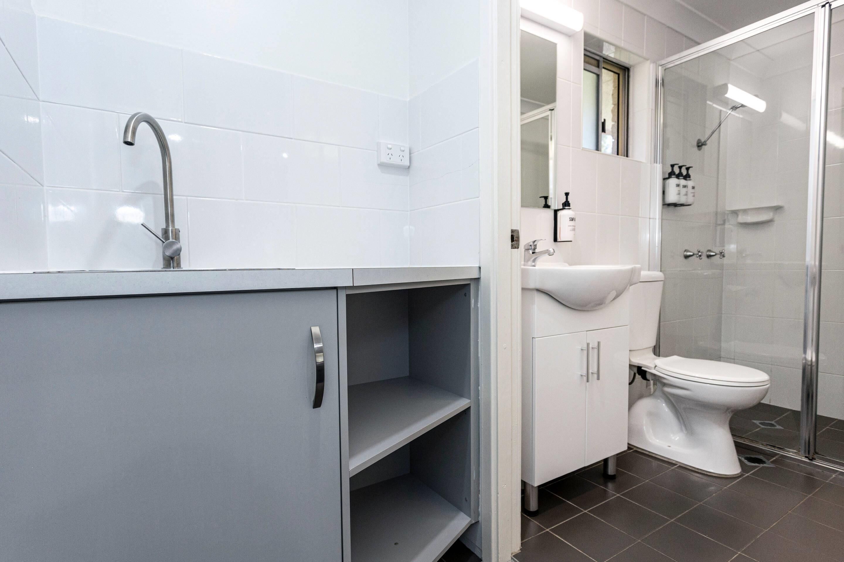 A modern bathroom with a shower, toilet, and sink.