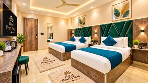 A hotel room with two beds, a desk, and a seating area.