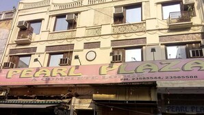 A building with multiple floors, featuring a prominent sign for "Pearl Plaza" and a "Green Chili Rest. & Bar" at the ground level. - Hotel Pearl Plaza (New Delhi)