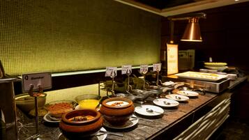 A buffet counter with various food items and serving utensils.