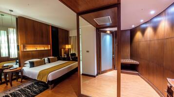 A hotel room with a large bed, bedside tables, a desk, a mirror, and a wardrobe.
