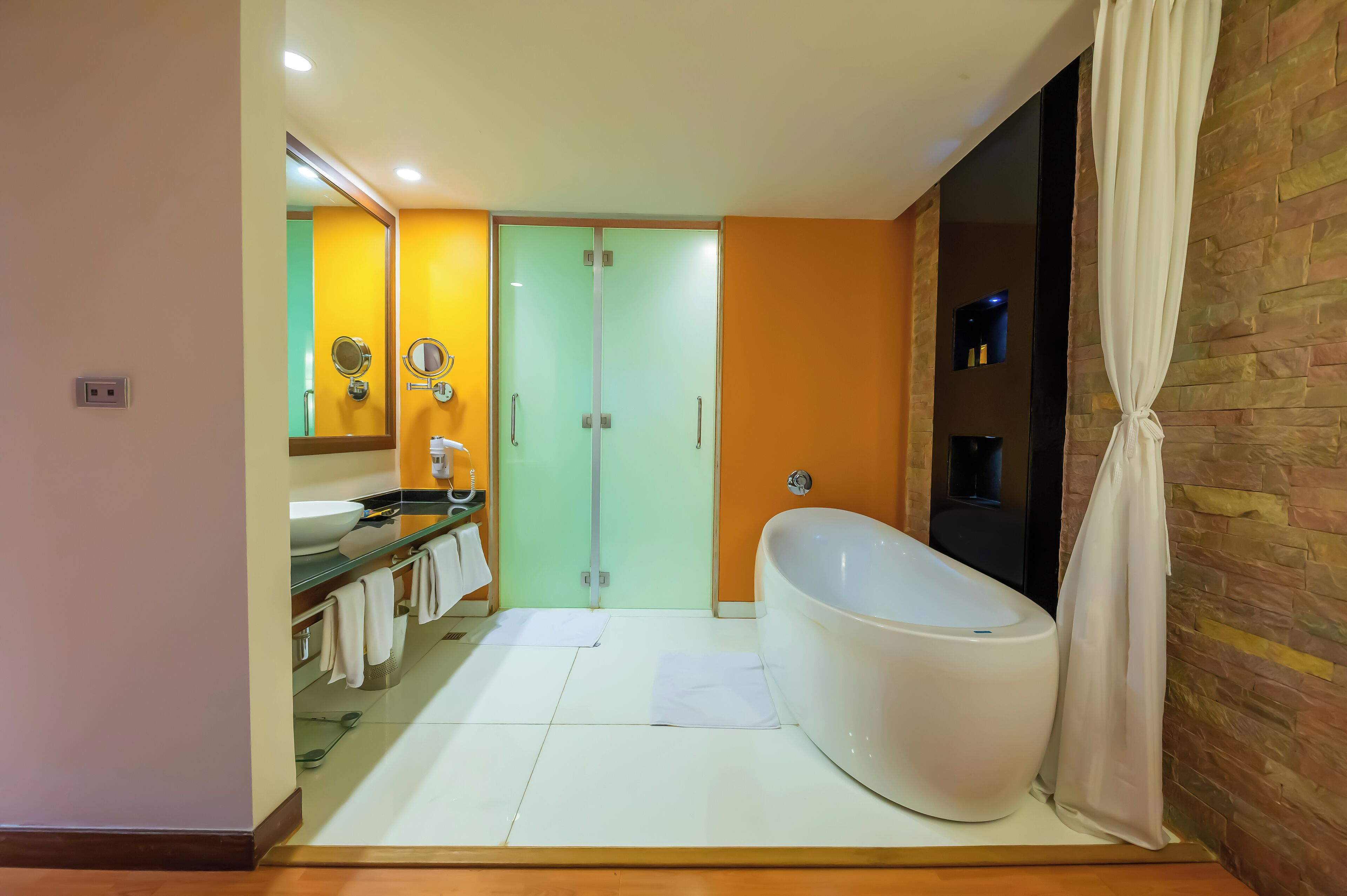 Un baño moderno con una bañera independiente, un tocador con espejo y una cabina de ducha de vidrio.