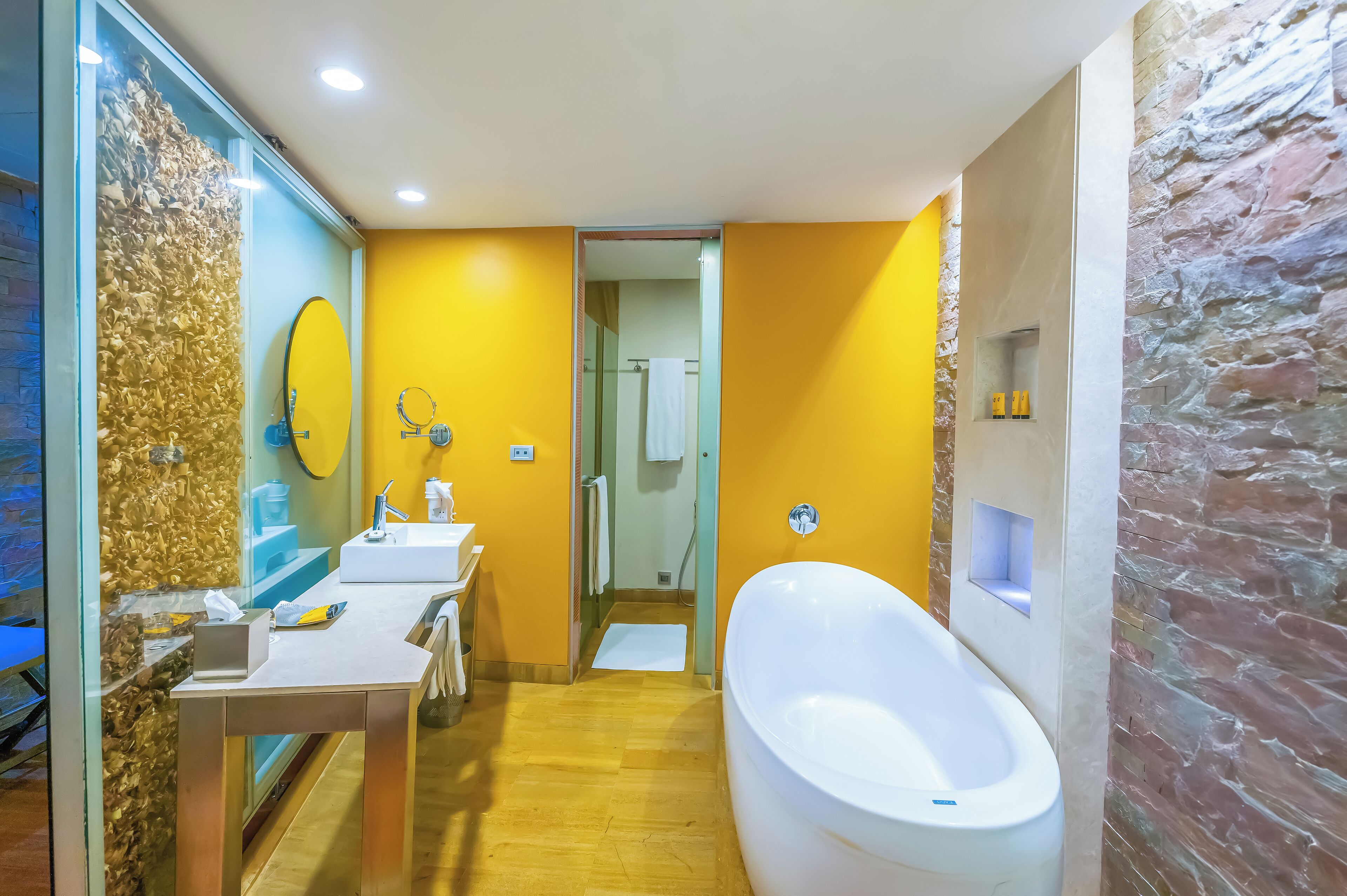 A modern bathroom with a large bathtub, a vanity with a mirror, and a shower area.