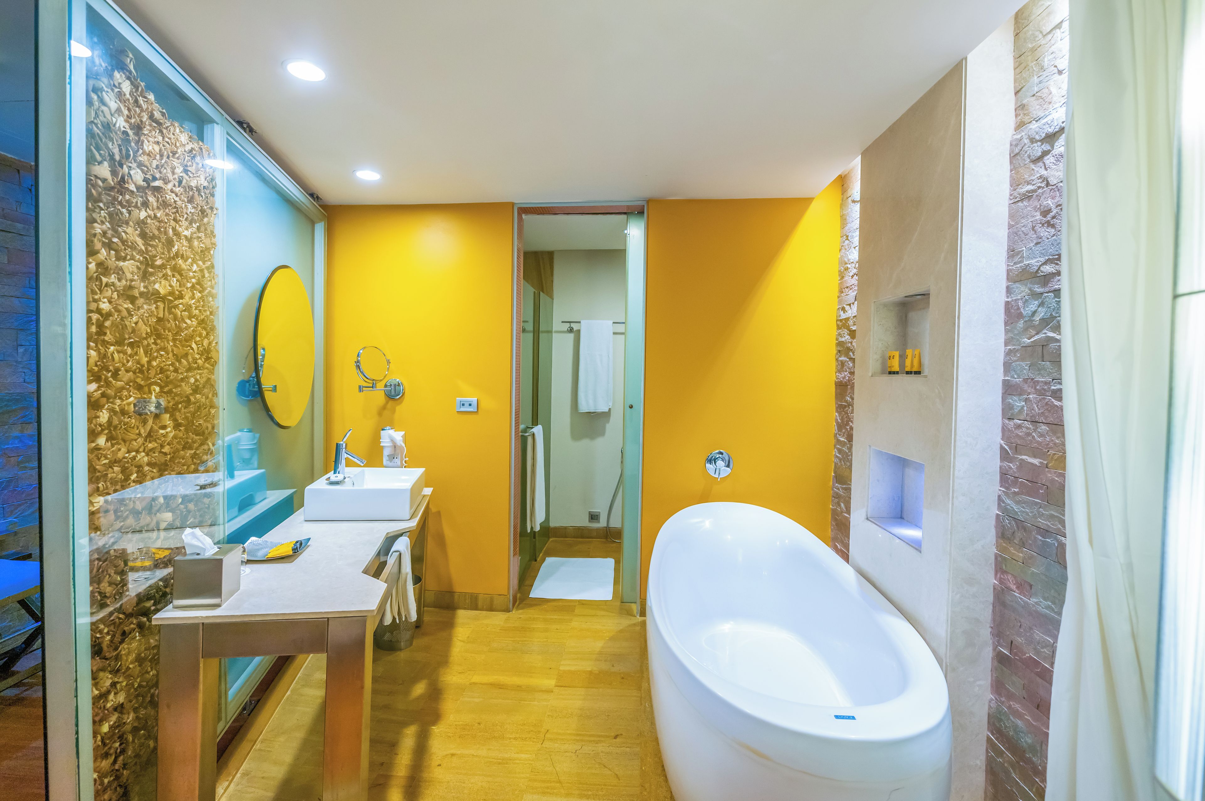 A modern bathroom with a large bathtub, a glass shower enclosure, and a vanity with a mirror.