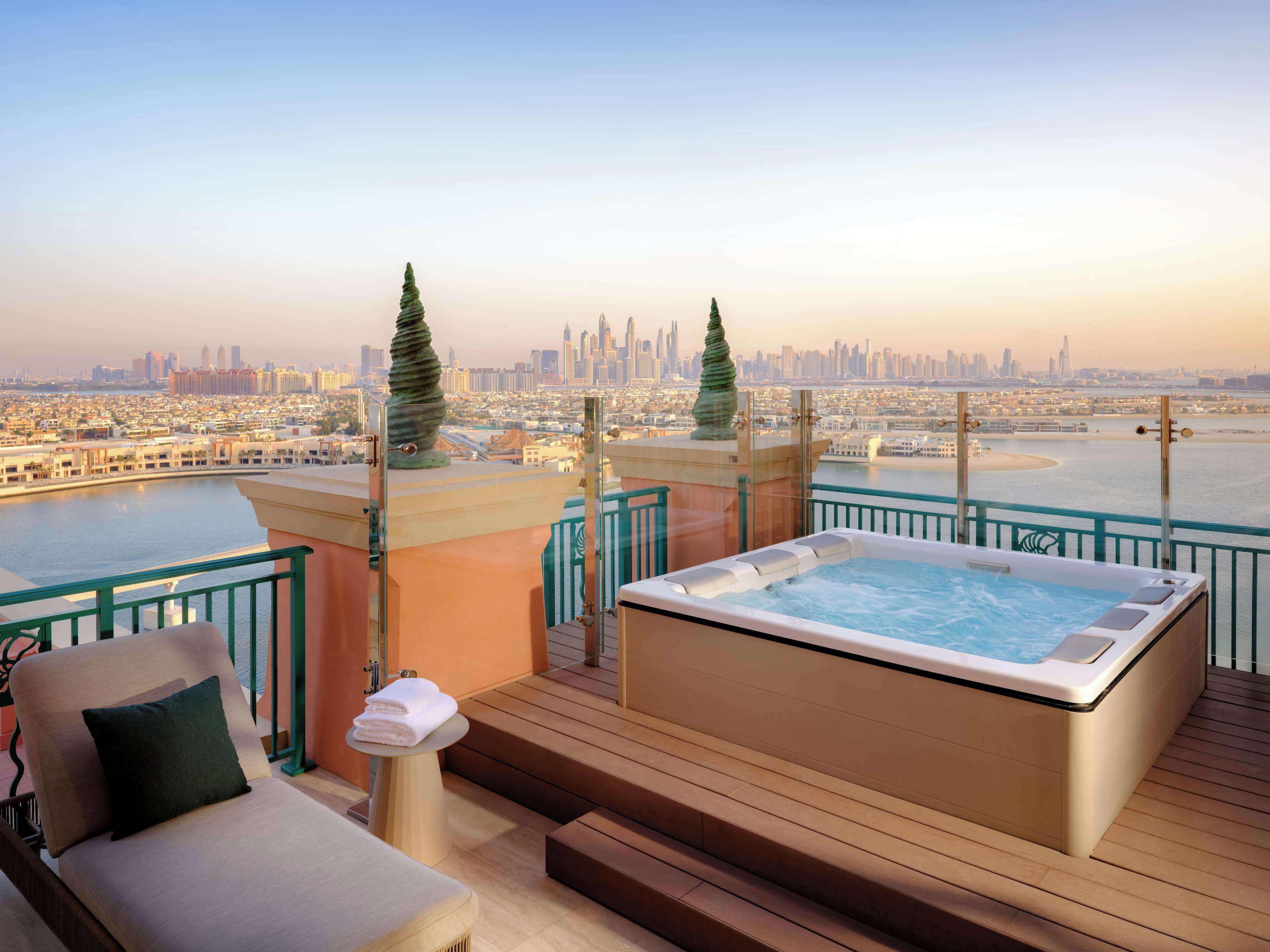Une terrasse sur le toit avec un jacuzzi, un espace salon et une vue sur la ville.