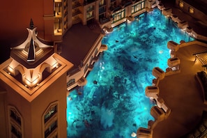 A large indoor pool with clear blue water, surrounded by stone architecture and multiple levels of balconies. - Atlantis, The Palm (Dubai)