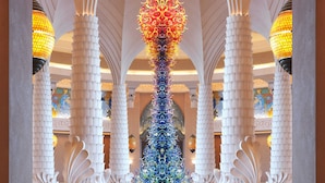 A grand lobby with high, arched ceilings and a central, ornate column.