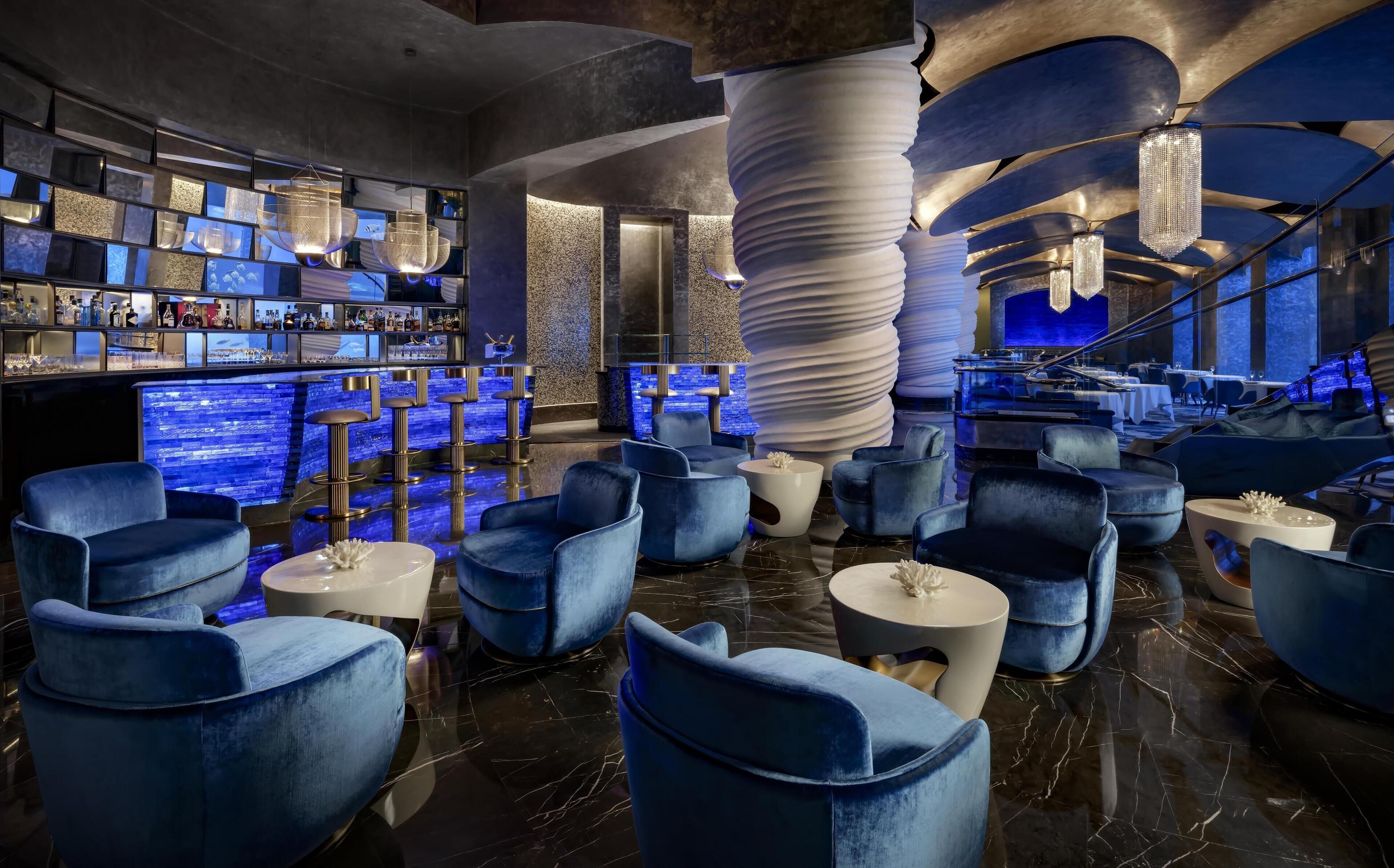 A modern bar area with multiple seating options, a bar counter, and a unique spiral column structure.