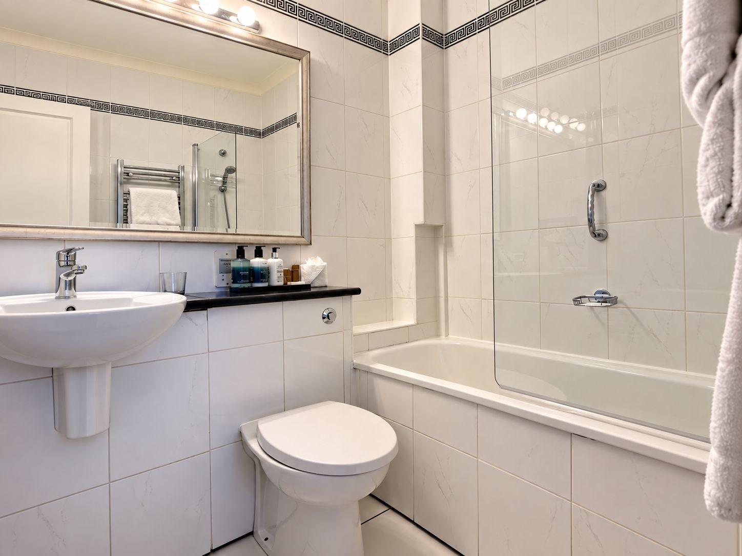 A bathroom with a white sink, a toilet, a glass-enclosed shower, and a bathtub.