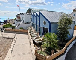 A building with a unique architectural design, featuring a curved roof and a flagpole.