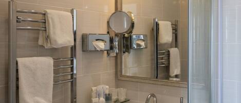 A modern bathroom with a glass shower enclosure, a sink with a chrome faucet, and a mirror above the sink.