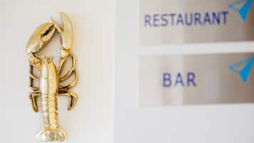 A gold lobster decoration and signs for a restaurant and bar.