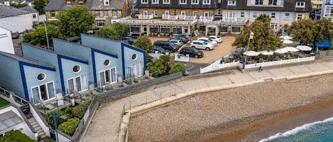 A coastal hotel with a parking area, beach access, and a view of the sea.