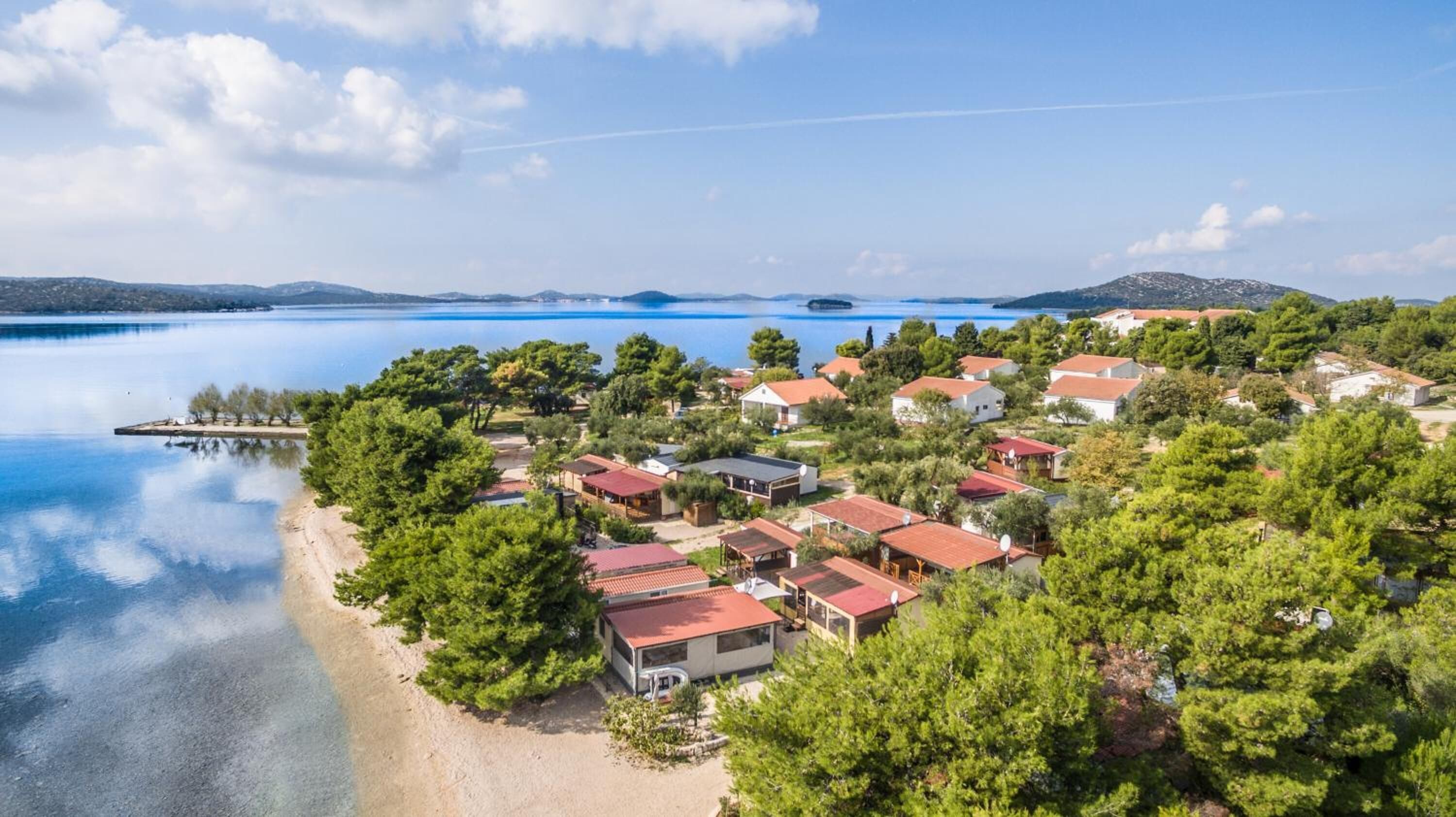 Ein Küstendorf mit Häusern, einem Strand und einem See.
