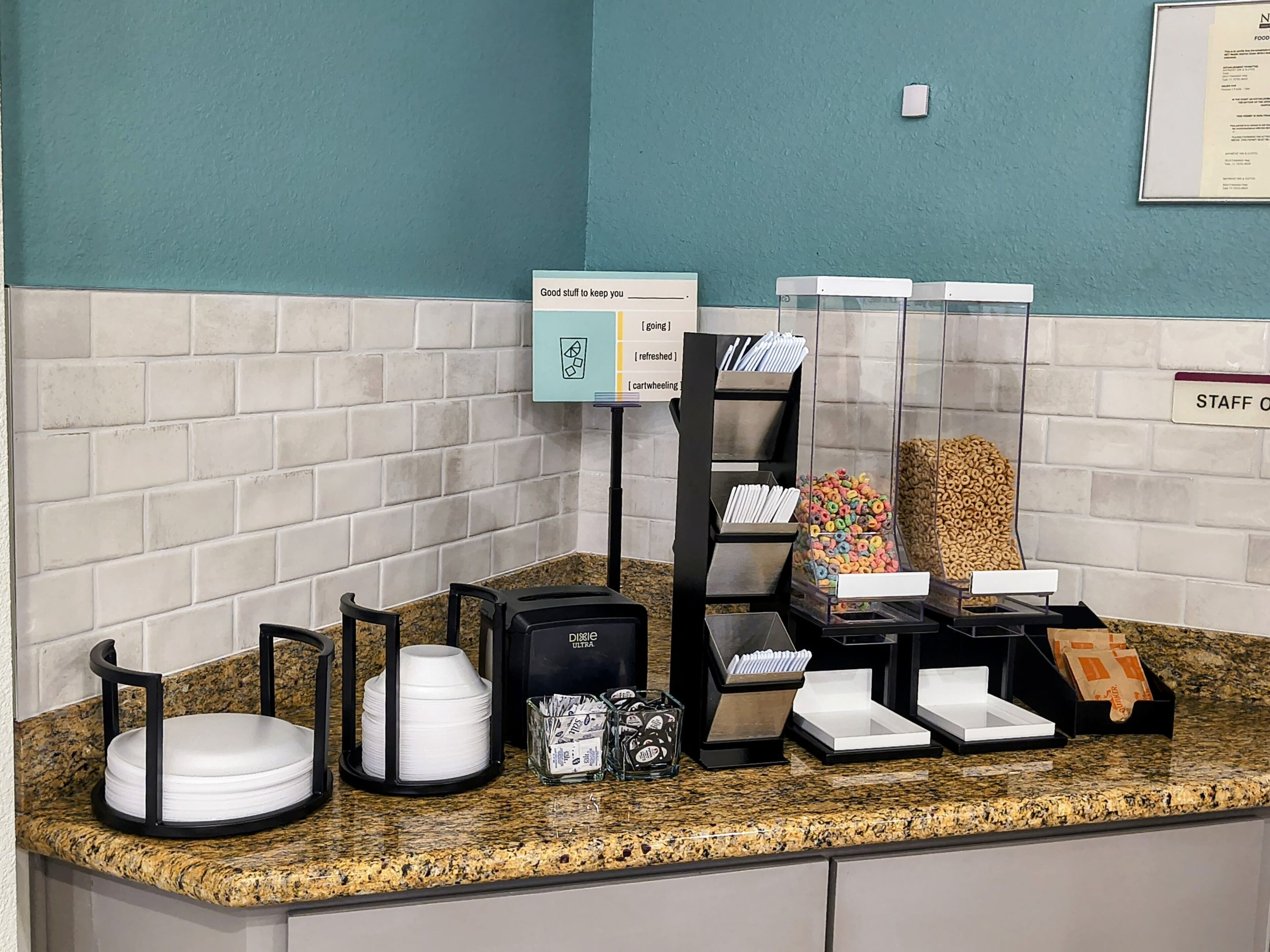 Mostrador d'auto-servei amb diversos serveis, com ara una màquina de cafè, dispensador de paper i presentació de cereals.
