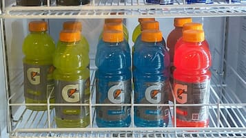 Un refrigerador lleno de diversas bebidas, incluyendo Monster Energy, Red Bull, Gatorade y Mountain Dew.