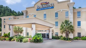 A Baymont Inn & Suites with a covered entrance, palm trees, and a clear sky. - Baymont by Wyndham Henderson (Henderson)