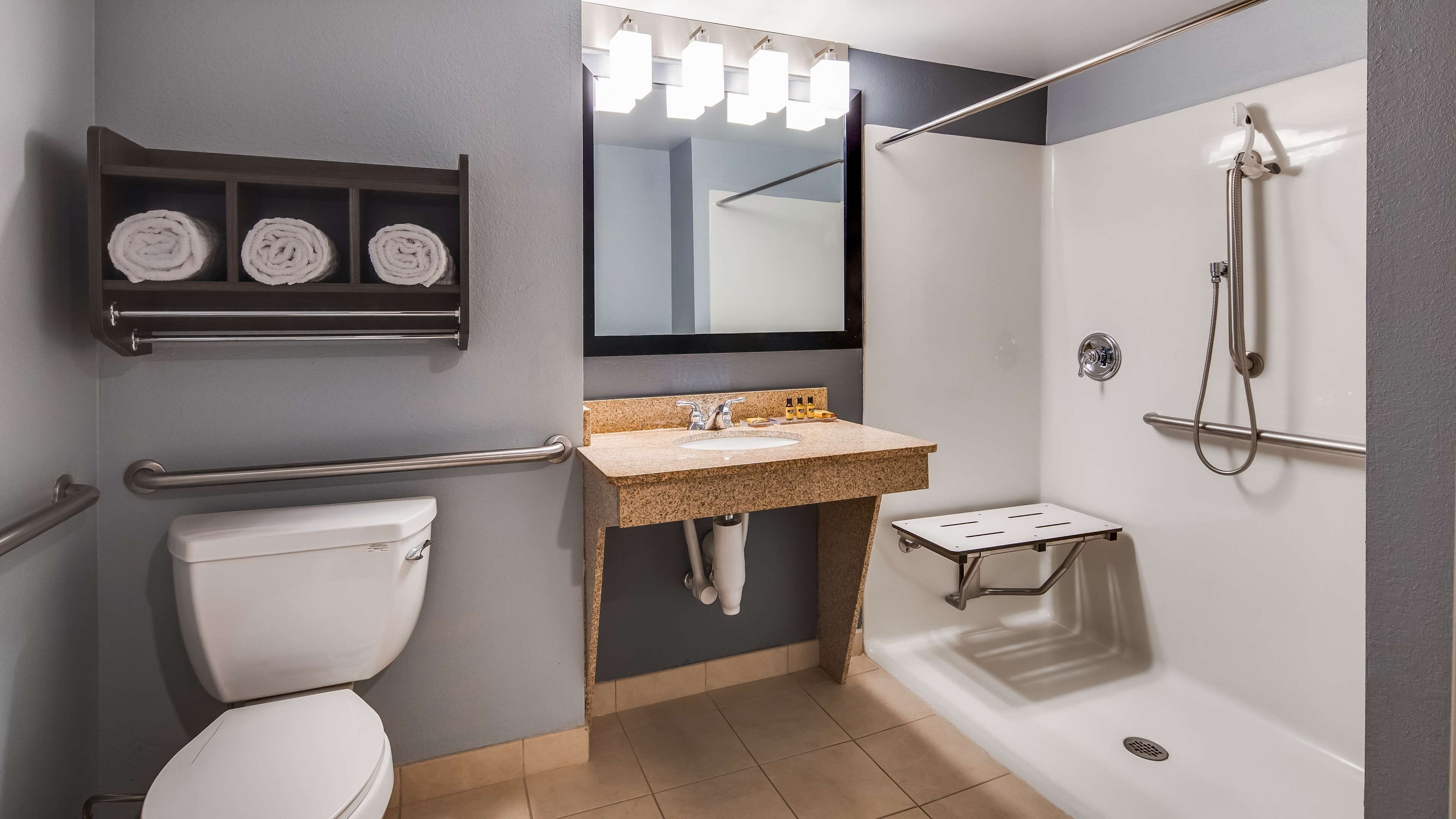 A modern bathroom with a toilet, sink, and shower.