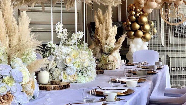 A table set for a formal event with white tablecloths, floral centerpieces, and a chandelier. - Oddfellows Chester Hotel and Apartments (Chester)