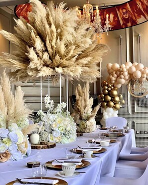 A table set for a formal event with white tablecloths, floral centerpieces, and a chandelier. - Oddfellows Chester Hotel and Apartments (Chester)