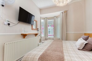 Tabla de planchar con plancha, cunas y ropa de cama 