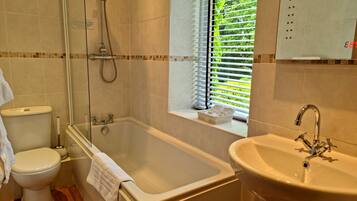 A bathroom with a bathtub, toilet, and sink.