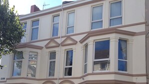 A multi-story building with a classic architectural style, featuring bay windows and a symmetrical facade. - Edgcumbe Guest House (Plymouth)