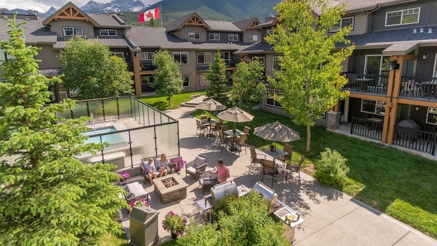 A resort with a pool, outdoor seating, and mountain views.