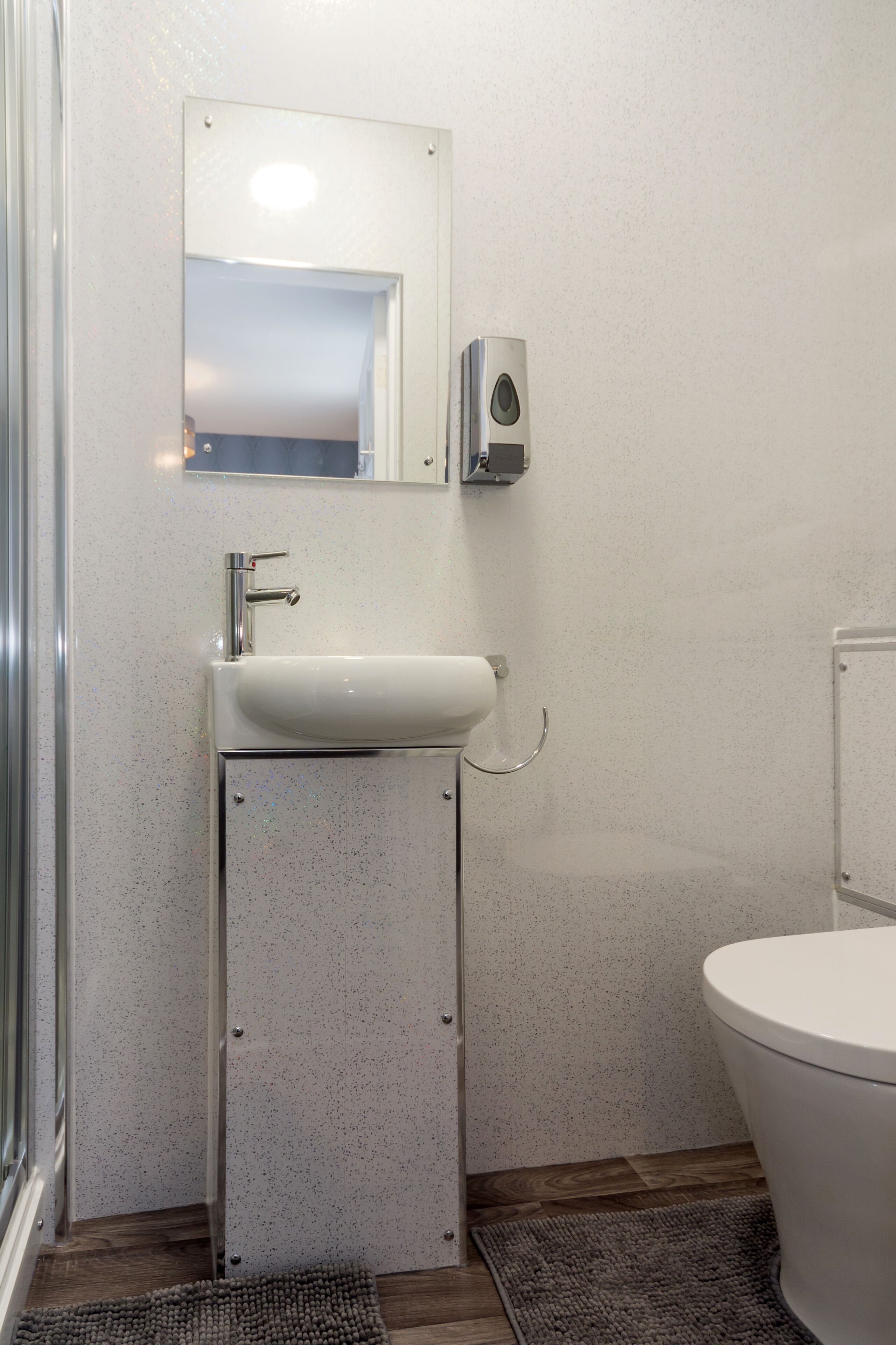 Ein Badezimmer mit Waschbecken, Spiegel und Toilette.