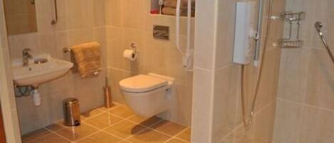 Un baño con lavamanos, inodoro y ducha.