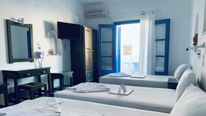 Una habitación de hotel con dos camas, un escritorio con una silla, un televisor y un armario.