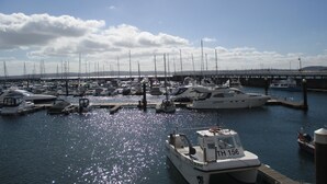 A marina with various boats docked, a bridge in the background, and a clear sky. - Grosvenor House (Torquay)