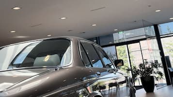 Ein modernes Interieur mit einem Auto, Oberlichtern und großen Fenstern.