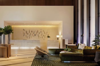 A conference room with a long table, chairs, and a screen displaying hotel branding. at Kimpton EPIC Hotel by IHG